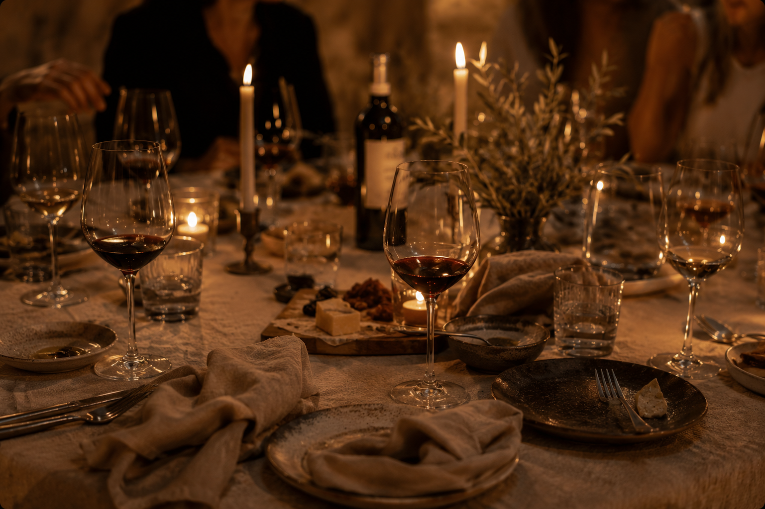 Candlelit table with wine glasses and linen